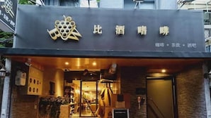 Entrada de hotel con diseño moderno, que presenta un logotipo y señalización sobre la puerta.
