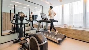 A modern gym with a treadmill, elliptical, and stationary bike. - Atour Hotel (Hangzhou)