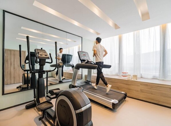 A modern gym with a treadmill, elliptical, and stationary bike. - Atour Hotel (Hangzhou)