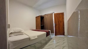 A bedroom with a bed, a wardrobe, and a door leading to another room. - Aldi's Bungalow and Homestay (Kuta)