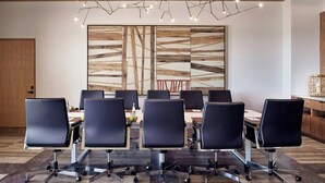 A conference room with a long table, black chairs, and a modern light fixture. - Zadun, a Ritz-carlton Reserve (San José del Cabo)