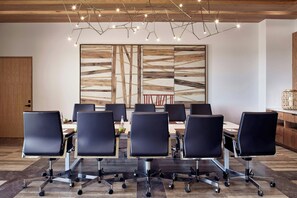 A conference room with a long table, black chairs, and a modern light fixture. - Zadun, a Ritz-carlton Reserve (San José del Cabo)