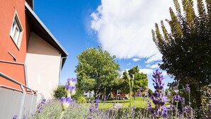 A garden with lavender plants and a building with a red facade. - Hotel Restaurant Löwen (Rust)