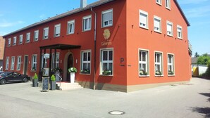 A red building with multiple windows and a sign reading "Löwen Hotel Restaurant". - Hotel Restaurant Löwen (Rust)