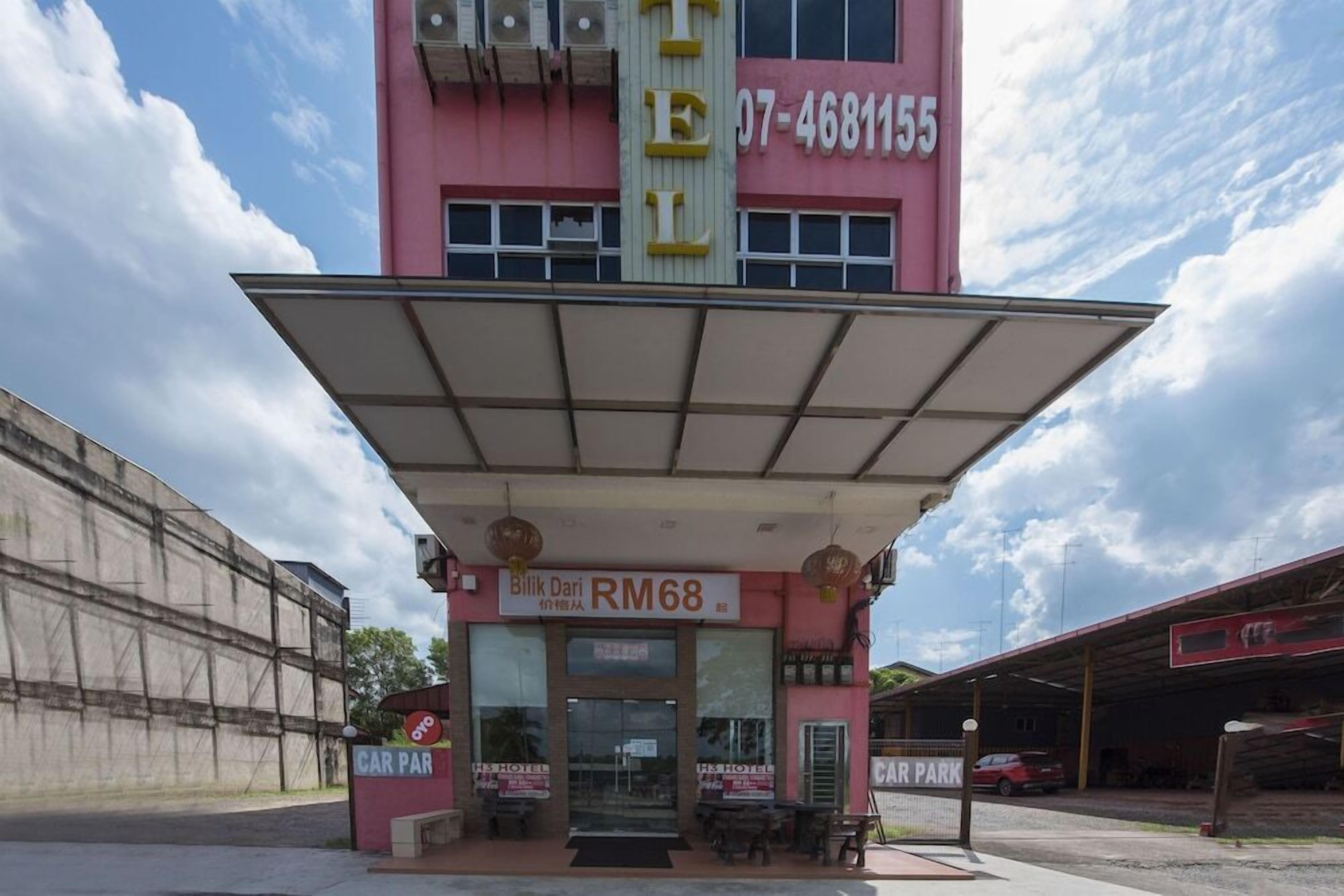 A pink building with a large overhang, a sign indicating RM68, and a car park sign.
