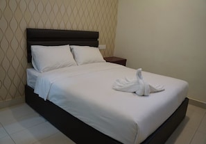 A neatly made bed with white linens and a towel arranged on the bed. - H3 Hotel (Batu Pahat)
