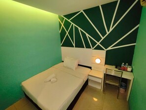 Une chambre d’hôtel avec un lit, une table de chevet, un bureau et un mur orné de motifs géométriques.