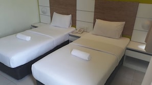 Two single beds with white linens and pillows, a bedside table with a phone, and a wall-mounted light fixture. - Bangi Business Hotel (Bandar Baru Bangi)