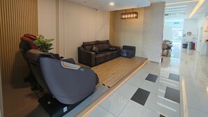 A modern lobby with a massage chair, a sofa, and a small table. - Bangi Business Hotel (Bandar Baru Bangi)