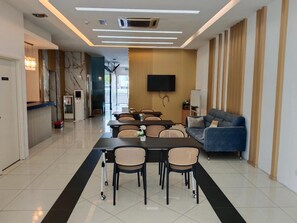 Un salon moderne comprenant un coin repas, un canapé, un téléviseur à écran plat et un escalier menant à un autre niveau.