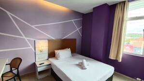 A hotel room with a bed, a desk, a chair, and a window with a view. - Bangi Business Hotel (Bandar Baru Bangi)