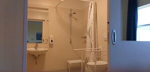 Une petite salle de bain avec une douche, un lavabo et des toilettes.