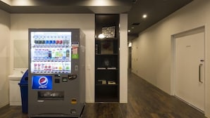 Un distributeur automatique orné du logo Pepsi, des toilettes et une porte portant l’inscription « BUREAU ».