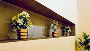 A wall-mounted shelf with three potted plants.