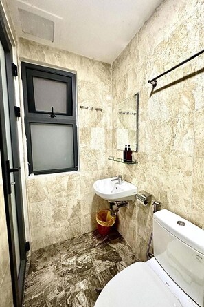 Ein Badezimmer mit Toilette, Waschbecken und Fenster.