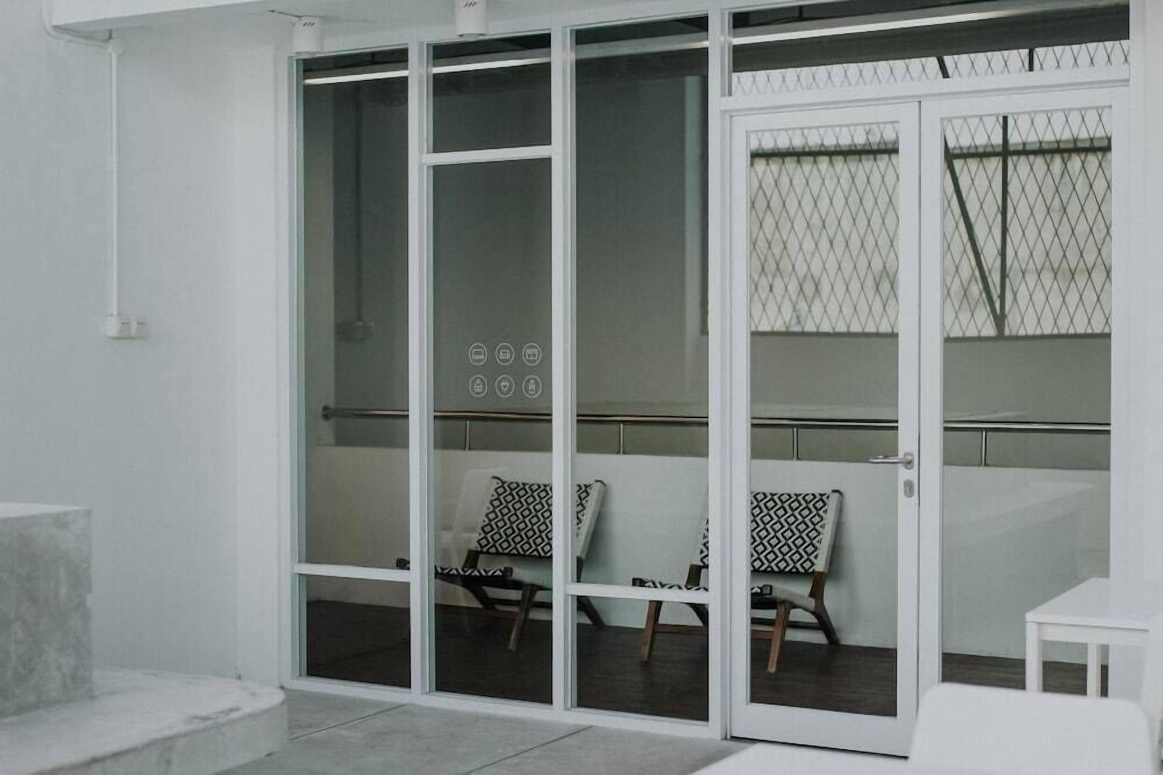 A room with a sliding glass door leading to a balcony with two chairs and a small table.