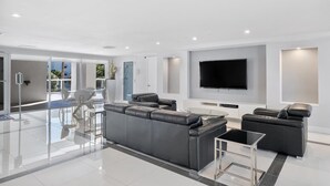 A modern living room with a large sectional sofa, a flat-screen TV, and a glass coffee table. - Entire condo in Sunny Isles Beach, Florida, United States (Sunny Isles Beach)