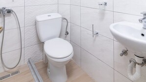 A modern bathroom with a toilet, shower, and sink. - Ragias Studios (Zakynthos)