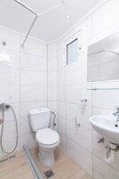 Un baño moderno con inodoro, ducha y lavamanos.