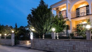 A two-story building with a stone wall and a balcony. - Ragias Studios (Zakynthos)