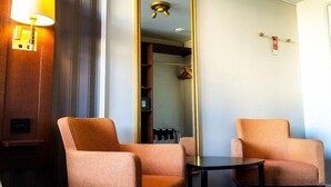 A hotel room with two armchairs, a small table, a mirror, a lamp, and a wardrobe. - Mariestads Stadshotell (Mariestad)