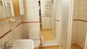 Un bany amb un rentapans, vàter i zona de dutxa.