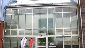 A building with large glass windows and a metal roof. - Hotel Torslanda Studios (Torslanda)