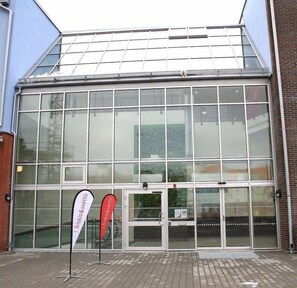 A building with large glass windows and a metal roof. - Hotel Torslanda Studios (Torslanda)