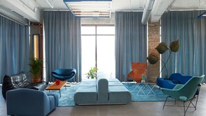 A modern living room with a sectional sofa, two armchairs, a coffee table, and a floor lamp. - Hotel Oddsson (Reykjavik)
