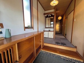 Ein traditioneller japanischer Raum mit einem Holztisch, einem Spiegel und einer kleinen Pflanze.