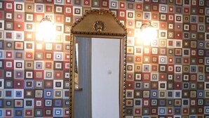 A bathroom with a mirror and patterned wall tiles.