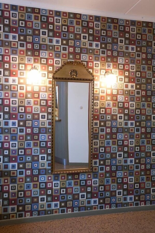 Un baño con espejo y azulejos con diseño.