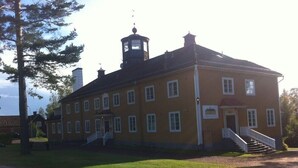 A large, yellow building with a central tower and a staircase leading to the entrance. - Insjöns Hotell Sweden Hotels (Insjon)