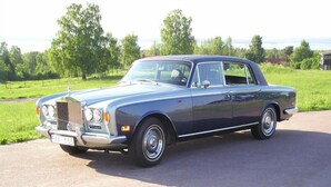 A classic Rolls-Royce parked on a paved area with greenery in the background. - Insjöns Hotell Sweden Hotels (Insjon)
