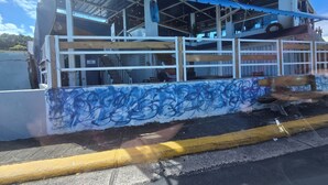 En bygning med markise, trappe og en væg med graffiti.