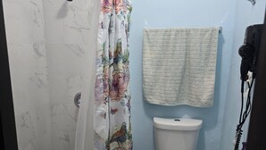 Et badeværelse med bruser, toilet og vask.