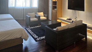 Une chambre d’hôtel moderne équipée d’un grand lit, d’un canapé, d’une télévision et d’un bureau.