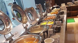 Un buffet avec différents récipients contenant de la nourriture et des ustensiles de service.