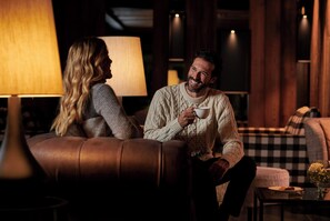 A cozy indoor setting with a leather couch, a table with a glass vase, and a lamp. - Le Massif Hotel & Lodge Courmayeur (Courmayeur)
