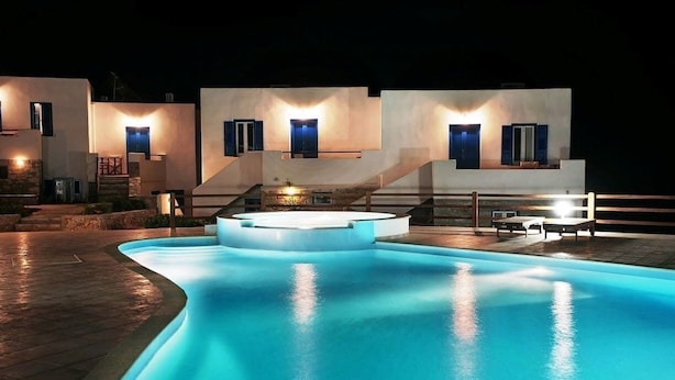 A modern villa with a swimming pool, outdoor seating, and a staircase leading to the upper level. - Amorgion Hotel (Amorgos)