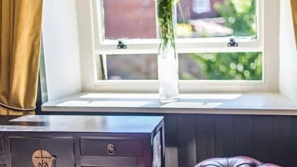 Una habitación con ventana, escritorio y silla.