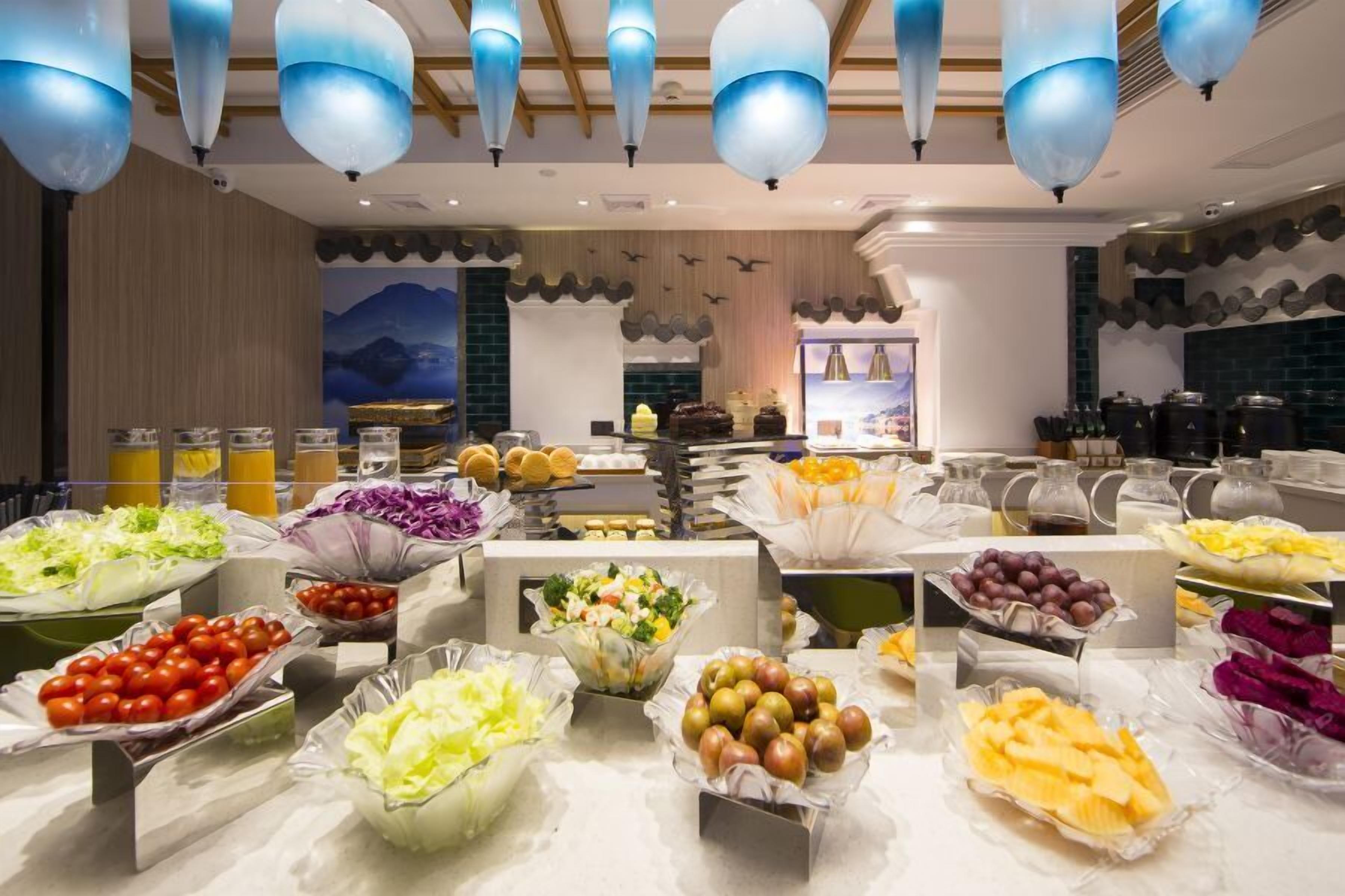 Een buffet met diverse gerechten en een keuken in de achtergrond.