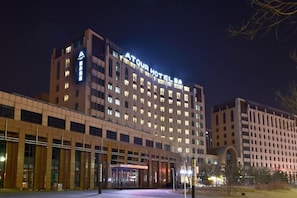Ein mehrstöckiges Hotel mit einer auffälligen Schilder, auf denen 'ATOUR HOTEL' steht.