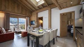 Un interior de madera con comedor, sofá y televisor.