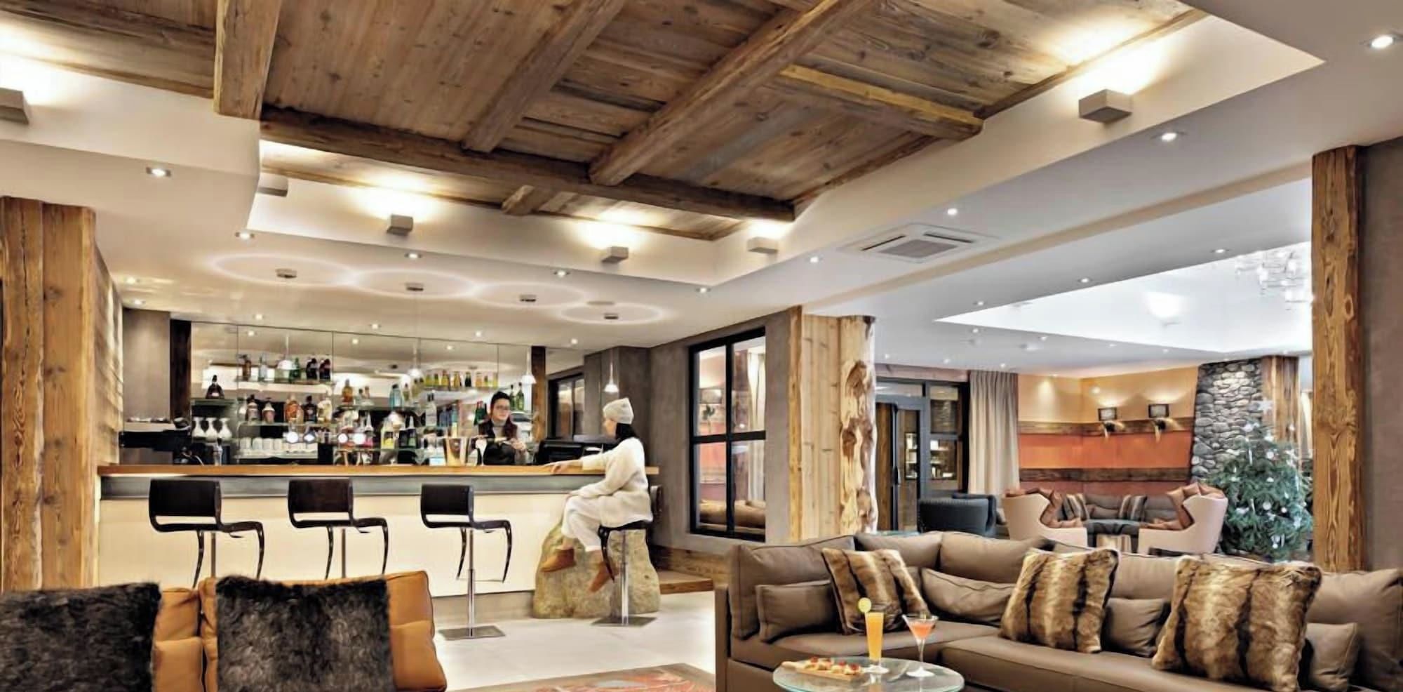 Un moderno vestíbulo de hotel con bar, zona de estar y grandes ventanales.