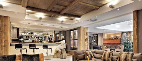 Un moderno vestíbulo de hotel con bar, zona de estar y grandes ventanales.