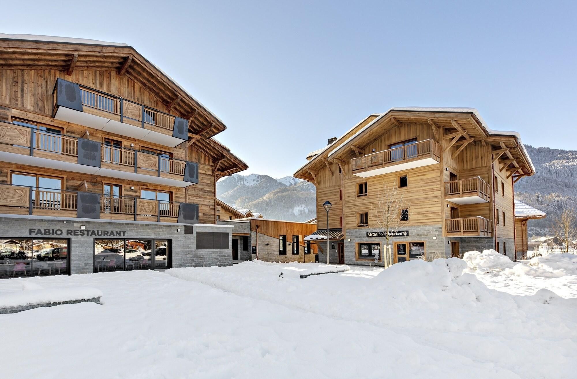 Un bâtiment en bois doté de balcons, un restaurant appelé FABIO RESTAURANT et une enseigne indiquant MGM Resorts.