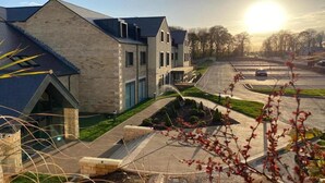 A modern building with a brick facade and a sloped roof, featuring a landscaped front yard with a pathway and a small garden area. - Hotel Van Dyk (Chesterfield)