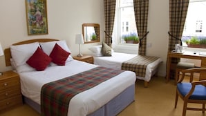 Une chambre d’hôtel avec deux lits, un bureau et une chaise.