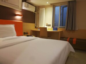 A hotel room with a bed, a desk, a chair, an air conditioning unit, a window with curtains, and a waste bin. - 7 Days Inn Premium Beijing Dongzhimen Airport Express Station (Beijing)